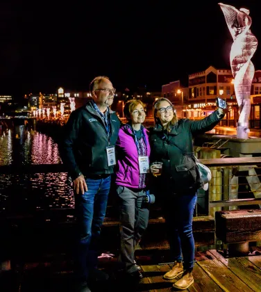 Members taking pictures together over the Alaska night skyline